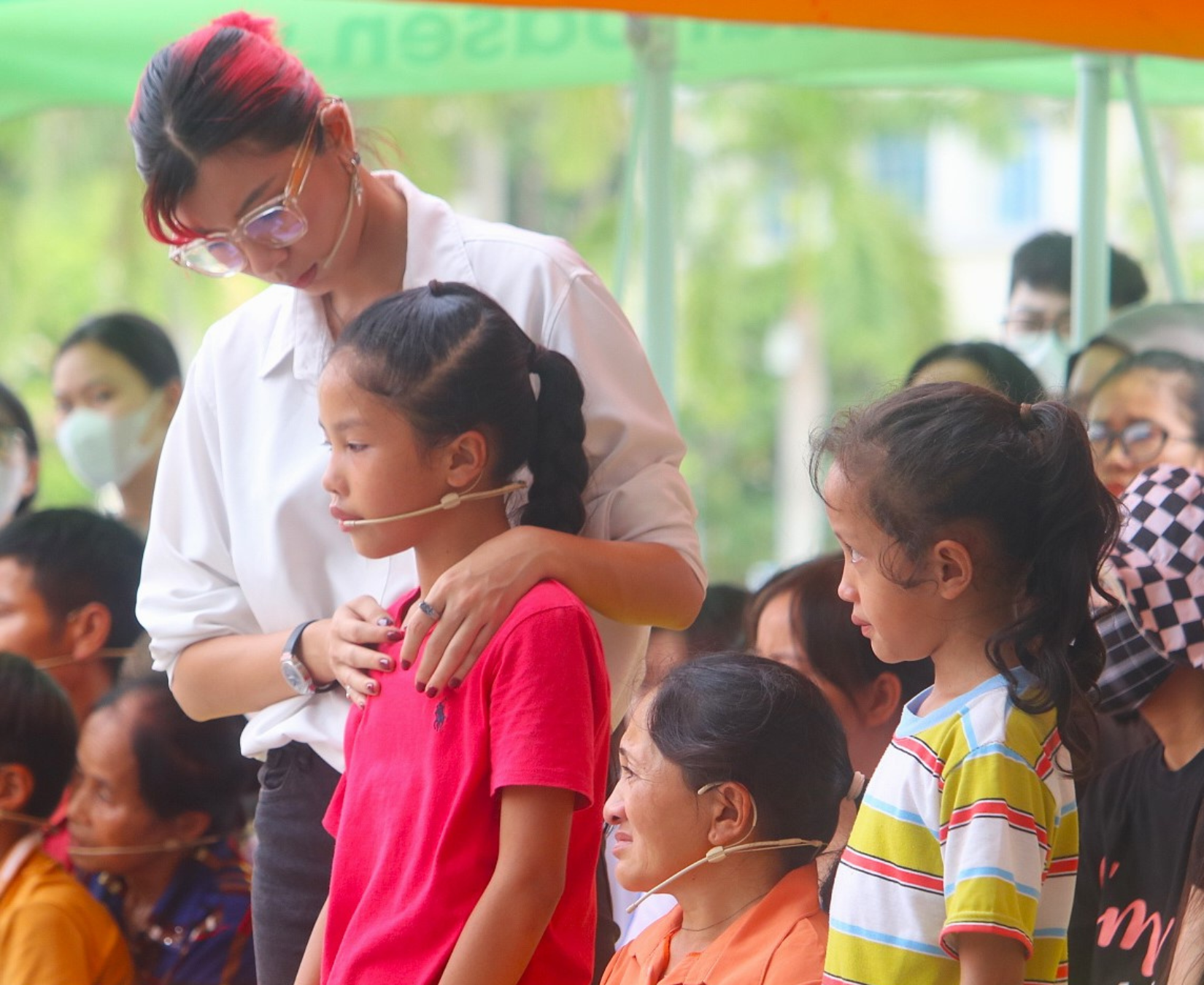 Diễn viên Đồng Ánh Quỳnh ôm các em nhỏ trên sân khấu, chia sẻ sự đồng cảm sâu sắc.