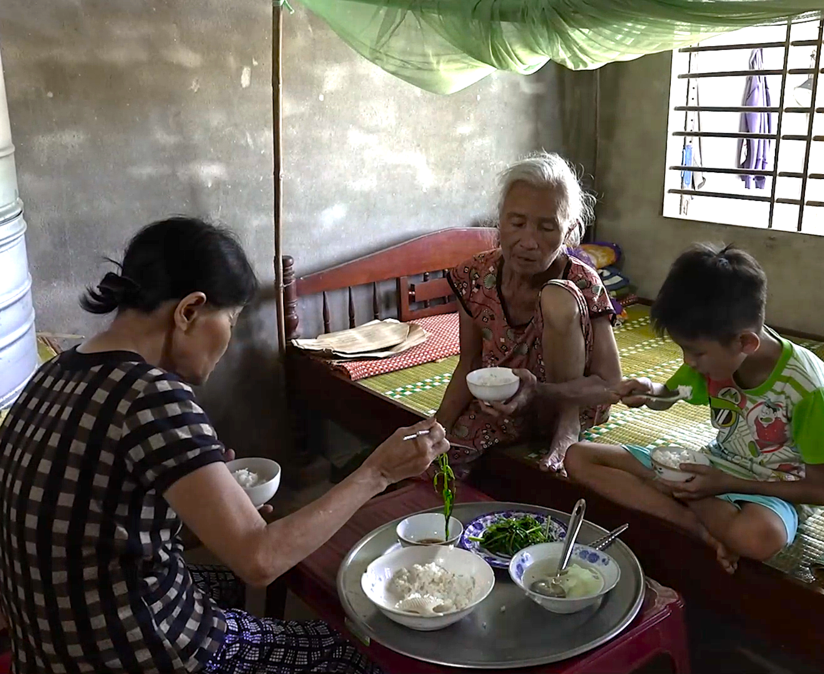 Bà cố, bà ngoại và em Huy với bữa cơm chỉ có rau luộc và cơm nguội.